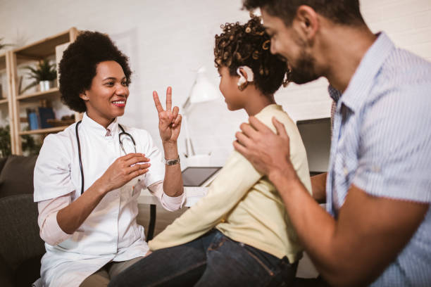 istock Smiling deaf girl learning sign language at doctor's office 1254844772