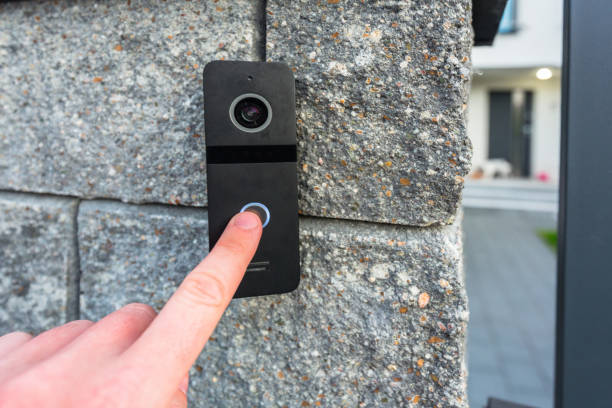 Hand pressing button of video intercom Hand pressing button of video intercom mounted on the stone wall doorbell photos stock pictures, royalty-free photos & images