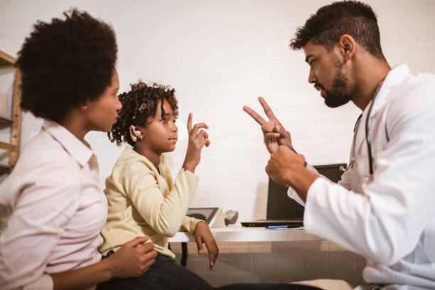 istock Smiling deaf girl learning sign language at doctor's office 1254846497