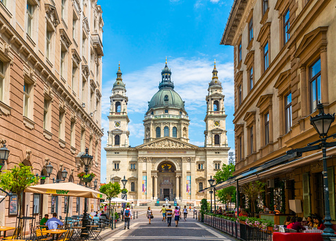 Budapest, Hungary - june 26th 2020 - Exterior of the grand church, basilica, seen from the  Zrinyi street during Corona time on a sunny day with some tourists visiting the square and restaurants