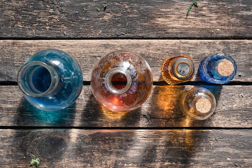 Colorful magic potion bottles on wooden table background.