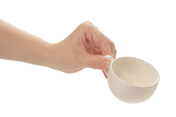istock Empty coffee cup in woman hand isolated on white. 1254852746