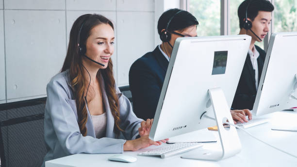istock Business people wearing headset working in office 1254853019