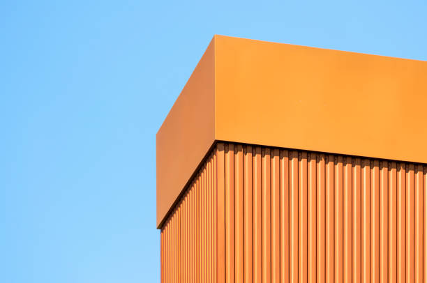 istock orange wall of a modern building against a blue sky 1254854298