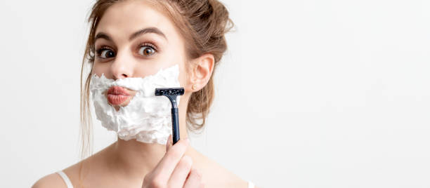 istock Woman shaving her face by razor 1254855030