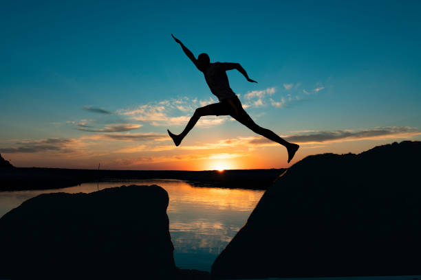 istock Man jump through the gap between hill. 1254856498