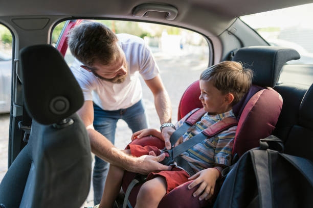 istock Father fastening the seat belt for his son 1254856911