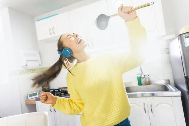istock Happy woman singing in the kitchen while cooking 1254858790