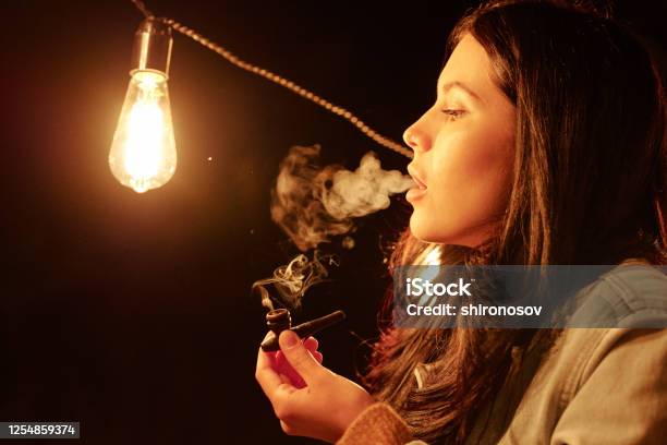 Young Woman With Dark Long Hair Holding Wooden Tobacco Pipe While Smoking Stock Photo - Download Image Now - iStock Young Woman With Dark Long Hair Holding Wooden Tobacco Pipe While Smoking Stock Photo - Download Image Now - iStock