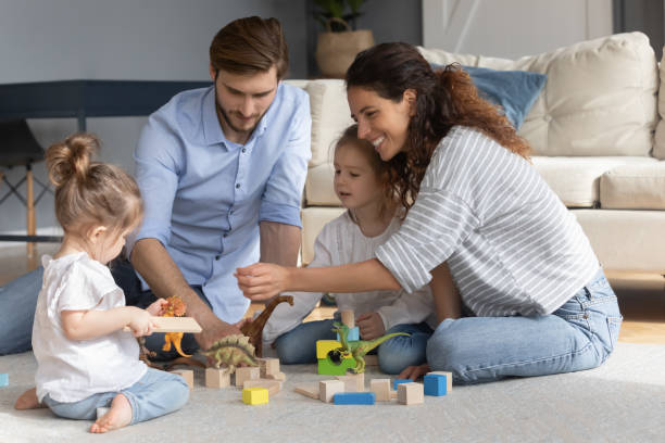 istock Happy parents with two little daughters playing with toys 1254860290
