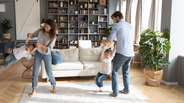 istock Happy young parents spinning laughing little daughters, having fun 1254860311