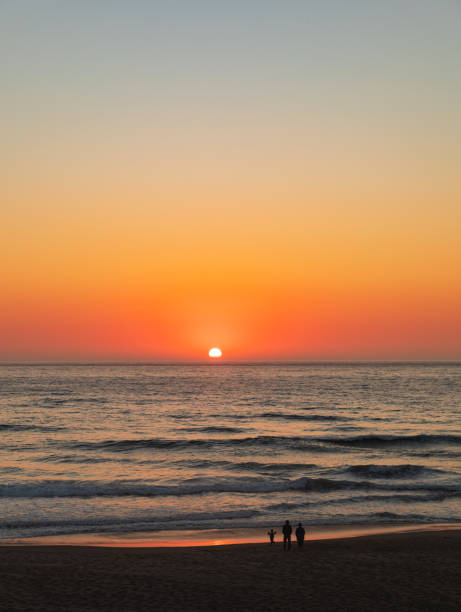 istock Vertical Image-Orange sunset glows across sky and water to a sandy beach 1254860553
