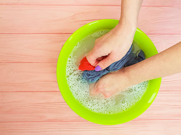 istock female hands wash clothes in a basin 1254860710