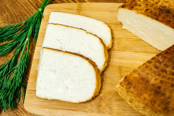 istock Sliced ​​cheese with herbs on a wooden board 1254863709