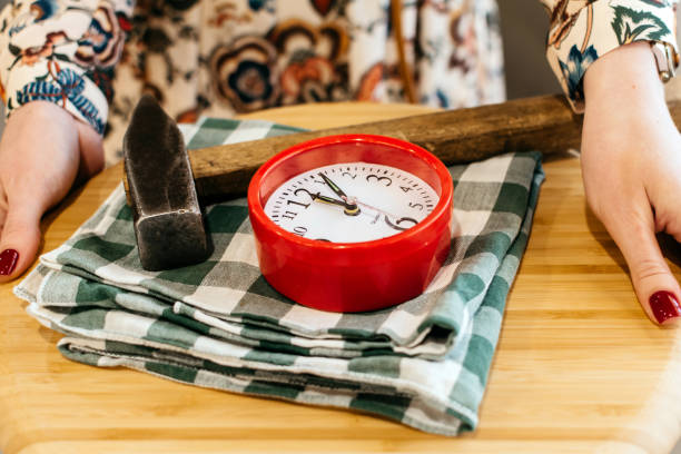 Alarm clock and hammer on a tray closeup Alarm clock and hammer on a tray closeup in Kirov, Kirov Oblast, Russia smash alarm clock stock pictures, royalty-free photos & images