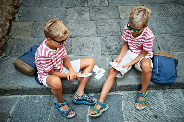 Kids tired of sightseeing decided to take a break and play cards.\nNikon D850