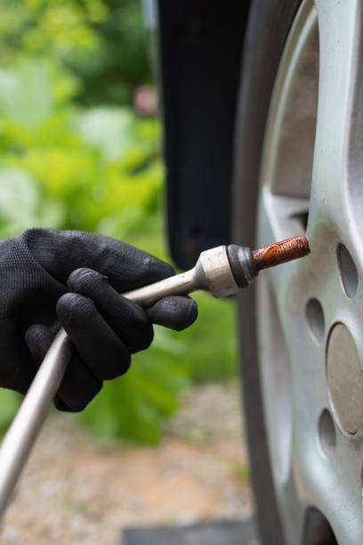 istock Woman changing car tire. Close-up view. 1254864380