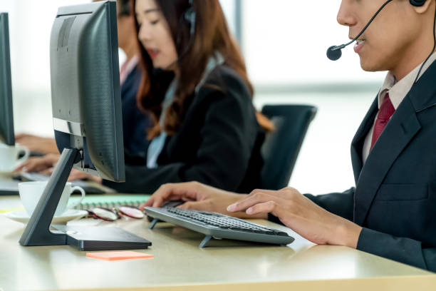 istock Business people wearing headset working in office 1254865484