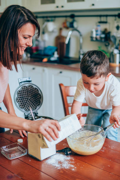 istock Mother and son preparing dough for waffles. 1254865672