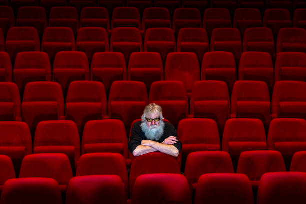 istock One man with white beard sits in Empty cinema or theatre 1254866230