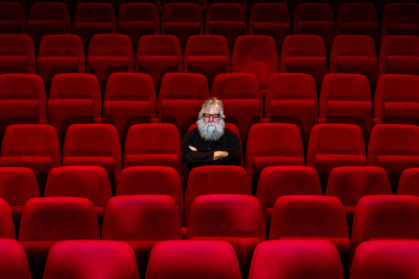 istock One man with white beard sits in Empty cinema or theatre 1254866780