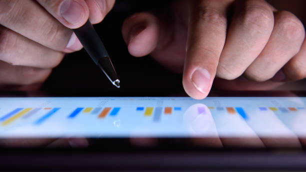 istock Businessman hand with pen analyzing annual report 1254868502