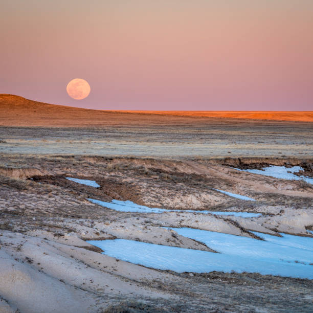 istock Sunset and moon rise over prairie 1254870943
