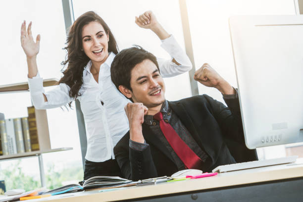 istock Two happy business people celebrate at office 1254871018