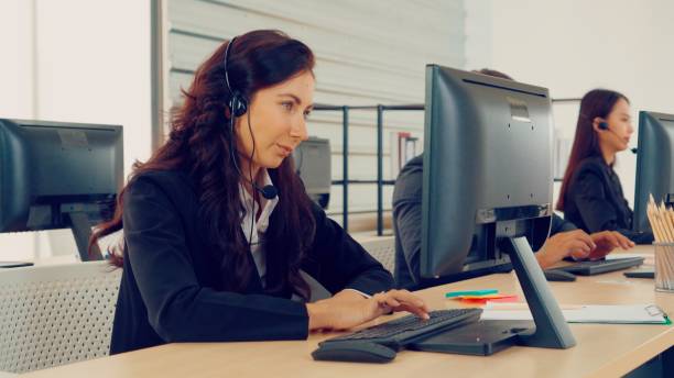 istock Business people wearing headset working in office 1254872402