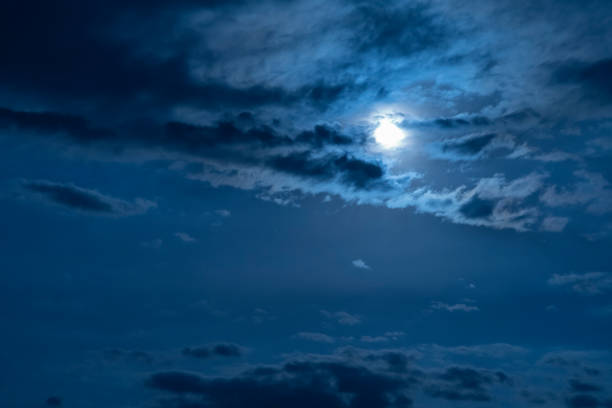 istock Beautiful night sky. The full moon illuminates clouds.  Nature background 1254872805