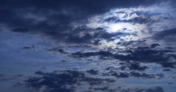 istock Beautiful night sky. The full moon illuminates clouds.  Nature background 1254873133