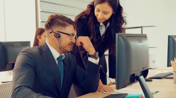 istock Business people wearing headset working in office 1254873295