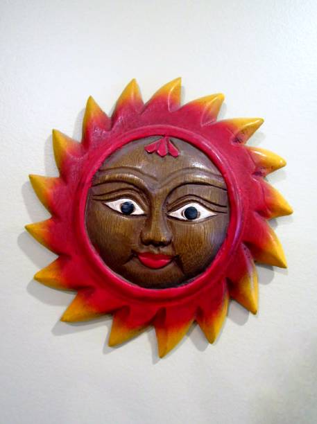 istock Wooden carved sun face plaque on white wall 1254873356