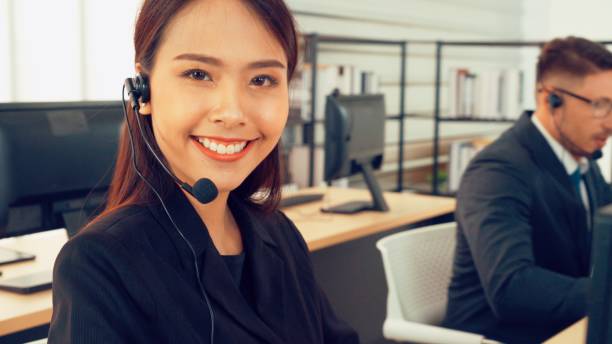 istock Business people wearing headset working in office 1254876455