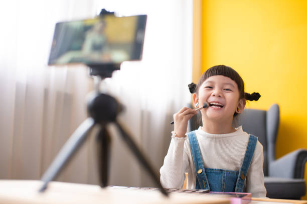 istock Little influencer teaching how to apply make-up for kids on live streaming video 1254877329