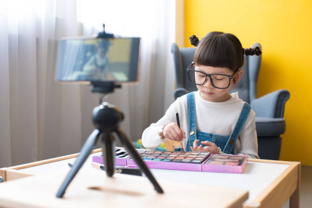 istock Little influencer teaching how to apply make-up for kids on live streaming video 1254877331
