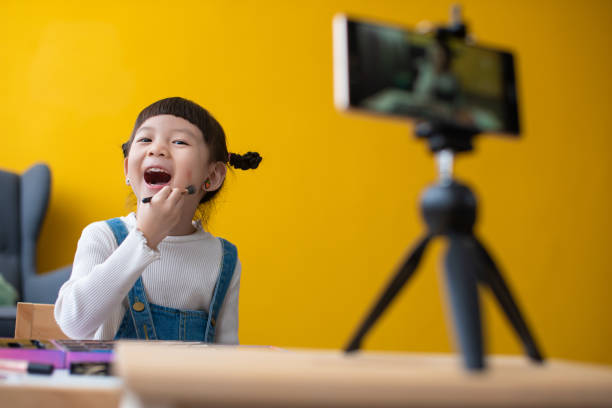 istock Little influencer teaching how to apply make-up for kids on live streaming video 1254878061