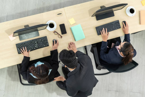 istock Business people wearing headset from top view in office working with computer 1254878937