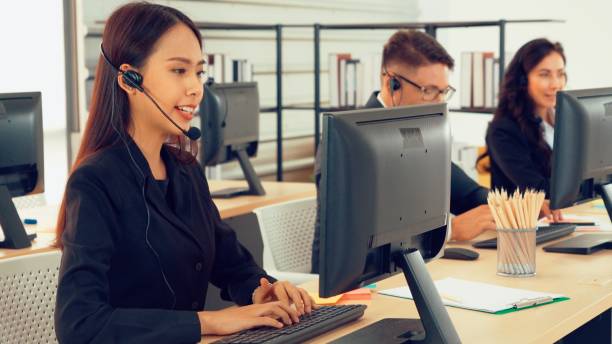 istock Business people wearing headset working in office 1254879016