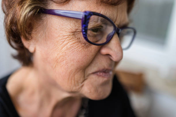 Older wrinkly woman wearing eyeglasses with a cheerful face expression