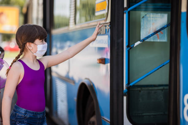 istock Girl wearing protective mask stopping the bus 1254883253