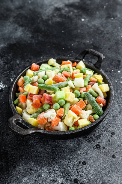 frozen raw vegetables in a pan. vegetarianism. black background. top view - edible mushroom frozen variation ice imagens e fotografias de stock
