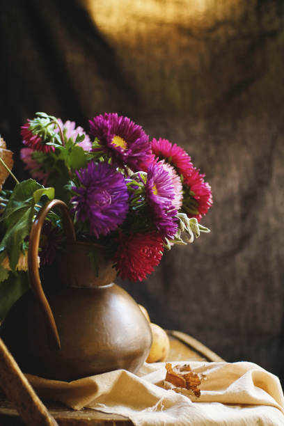 A bouquet of asters in a copper jug
