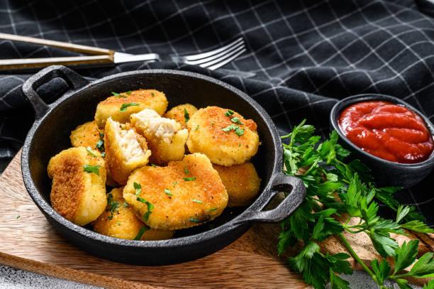 istock Crispy fried chicken nuggets in a pan with ketchup and herbs. White background. Top view 1254886862