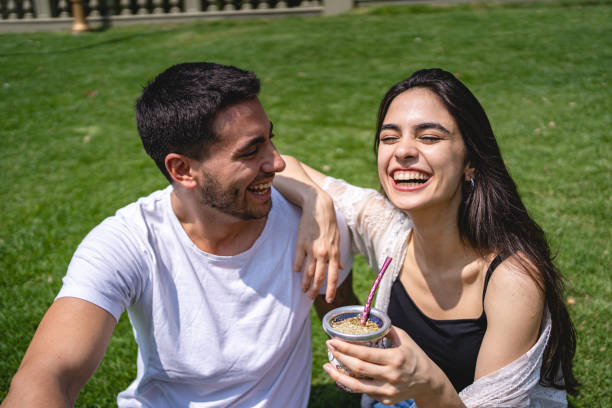 istock Young couple laughing while enjoying their time at a park drinking tea 1254888867