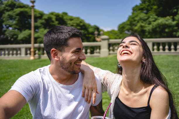 istock Cute ecstatic couple having fun at a park while drinking yerba mate 1254890579