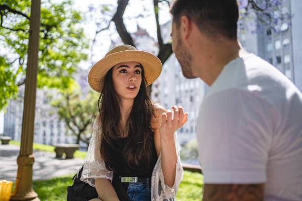 istock Beautiful young couple flirting and talking outdoors on a park bench 1254890598