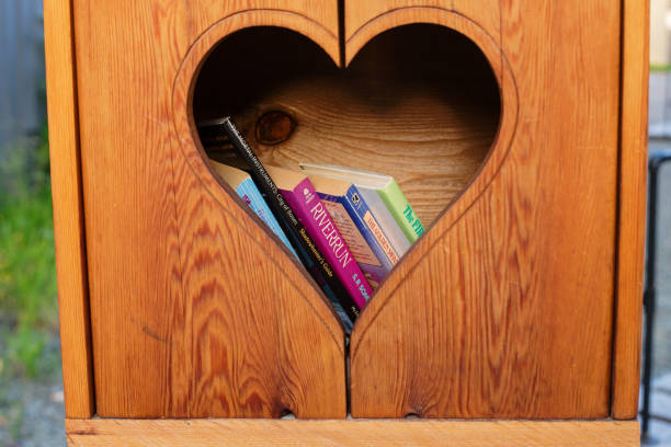 Book Library Smithers, Canada - June 27, 2020. A book exchange library has a heart-shaped window and a few books inside. smithers british columbia stock pictures, royalty-free photos & images