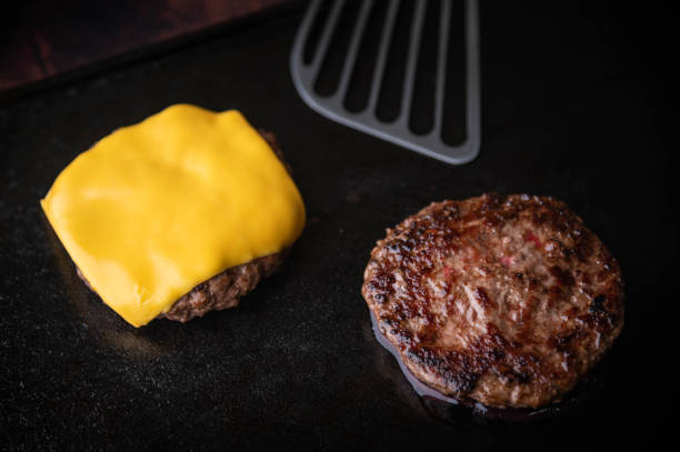 istock cooking burger patty on iron pan 1254897625