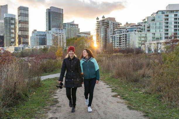 istock Female friends laughing while on a walk through city park at sunset 1254897933